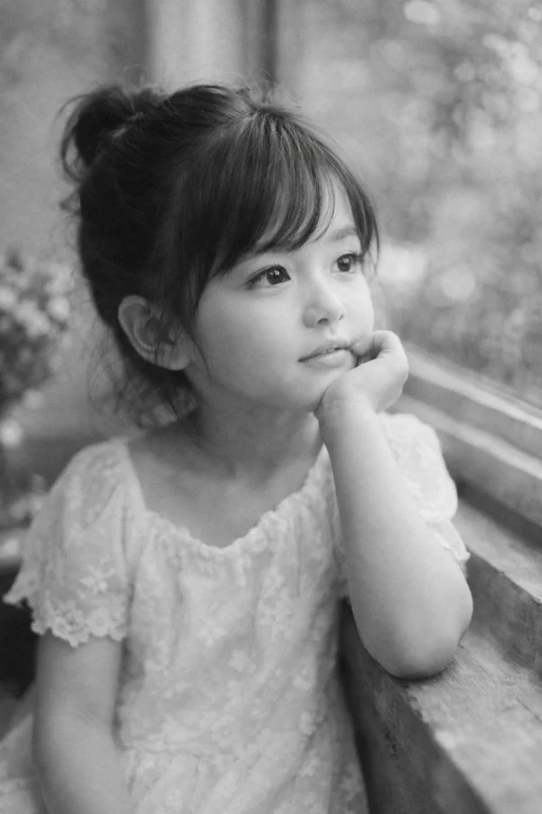 示意圖：Neopan 400CN 人像攝影，窗邊女孩，柔和光線，無顆粒感膚質，染料雲朵效果