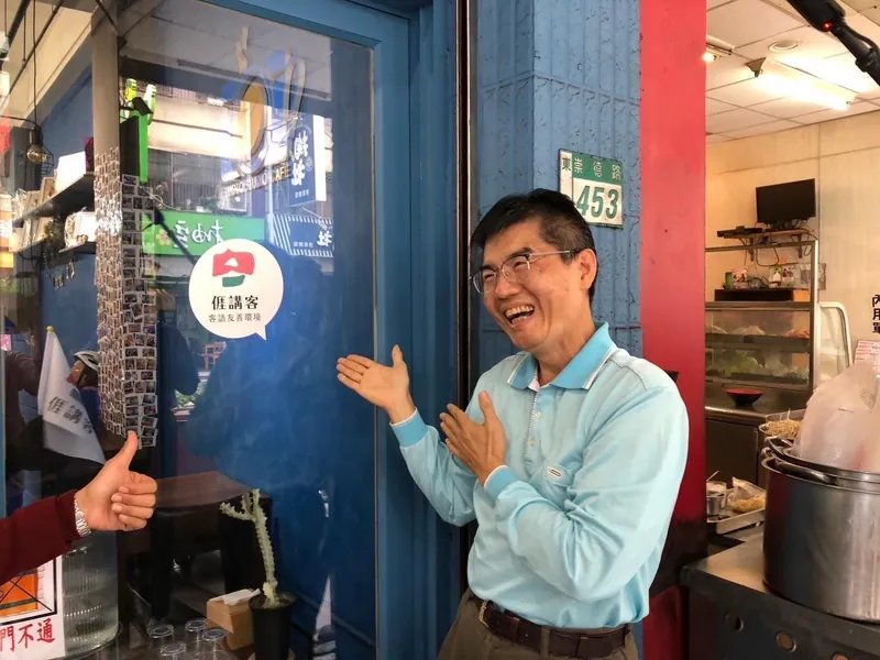 2023 年全國客家日，老闆劉政中指著店門口剛貼上的「𠊎講客 客語友善環境」標章