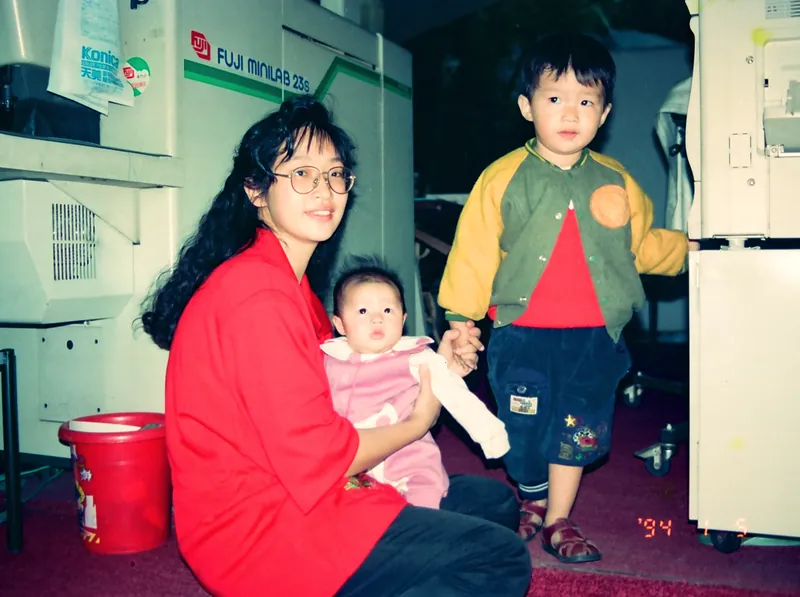 1994 年，年輕時的老闆娘和兩個孩子在崇德路的店裡