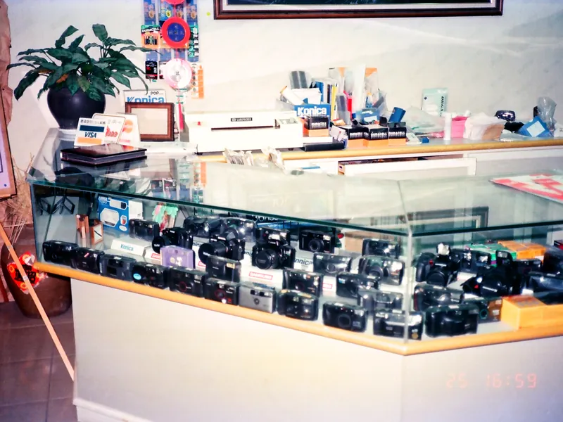 修色後的老照片：1990 年代店裡擺滿相機的玻璃櫃