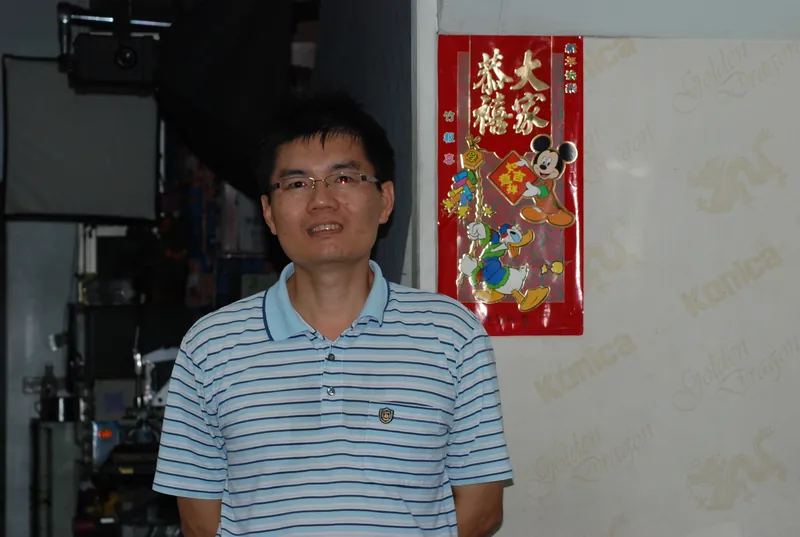 2008 年，老闆劉政中坐在恆美的攝影棚裡，後面是攝影燈